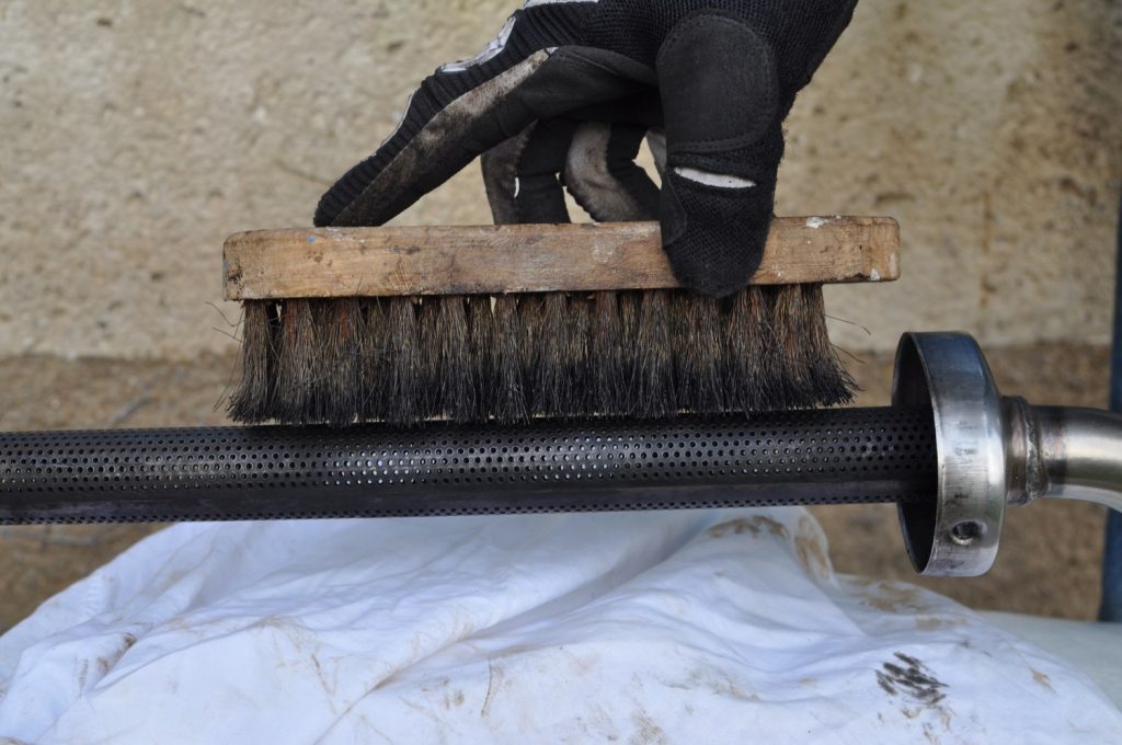 Une brosse métallique pour nettoyer la mitraillette du pot