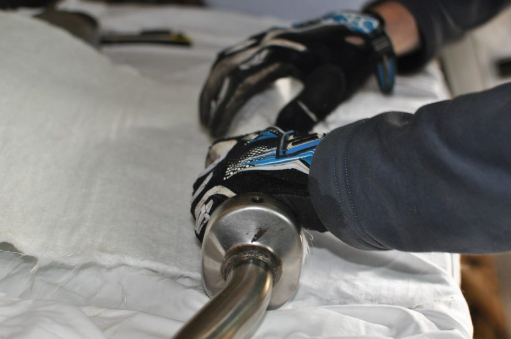 La laine de roche neuve est enroulée autour de la mitraillette avec des gants